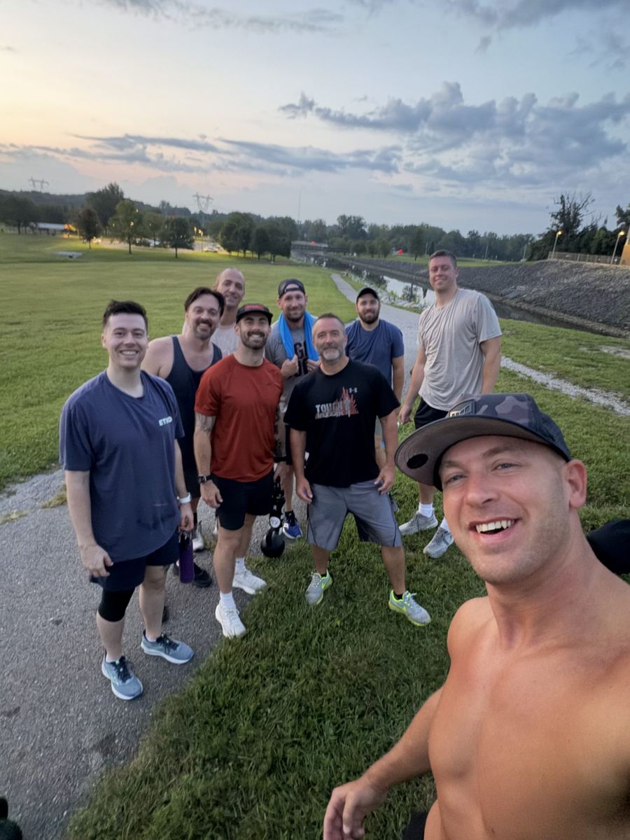 A larger group on the grass by the track at sunrise
