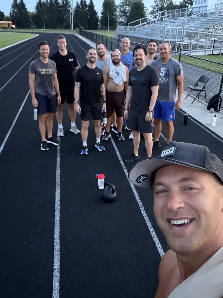 More than a dozen men on the track after the workout